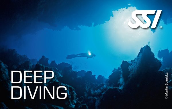 Дайвер с фонарем в глубокой пещере рифа — Deep Diving